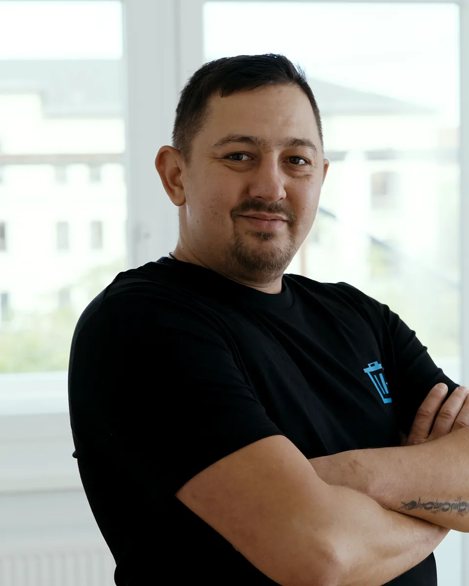 Andreas Martin von Sorglos Entrümpeln mit kurzem dunklem Haar und Bart im schwarzen T-Shirt mit Sorglos-Logo