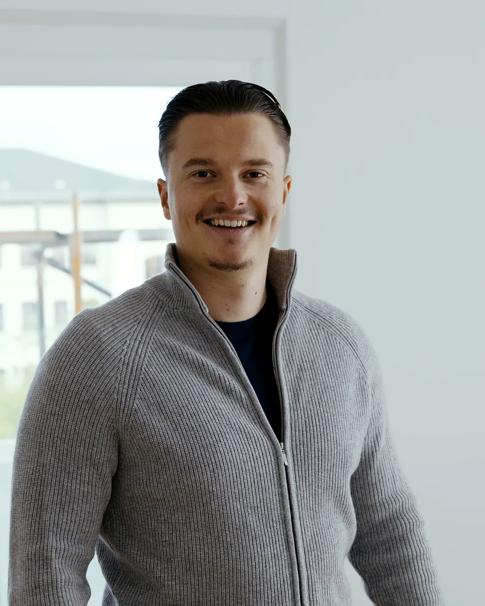 Ruben Bestfleisch, Inhaber von Sorglos Entrümpeln, im grauen Strickpullover in einer hellen Wohnung
